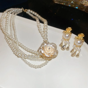 Detail of multi-layer pearl necklace with rose pendant and matching crystal tassel earrings