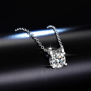 Macro shot of a brilliant-cut moissanite necklace featuring a classic four-prong silver setting