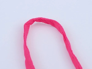 Détail de la bandoulière de robe en mousseline rose avec couture au point de croix