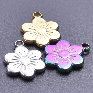 Macro view of plum blossom pendants in gold, silver, and rainbow stainless steel