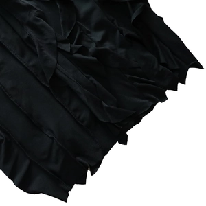 Gros plan des épaisseurs à volants et de la texture douce de cette robe de soirée noire