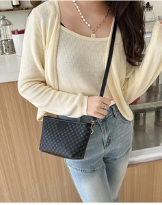 Mini crossbody bag with geometric pattern shown in a lifestyle cafe setting with model