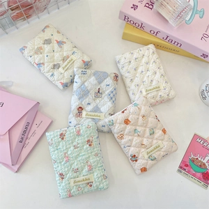 Detailed view of quilted cotton travel organizers with floral and bear patterns
