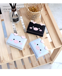 Detailed view of trifold cartoon pig wallets in black and light blue faux leather