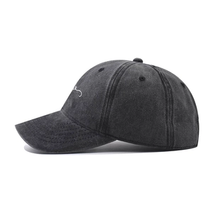Detailed view of embroidery on a washed cotton baseball cap with vintage finish