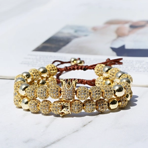 Detailed shot of gold-plated crown bracelet with sparkling zircons on woven cord