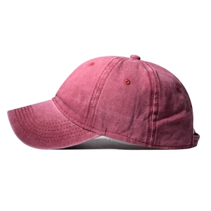 Detail of dark red washed cotton baseball cap with ventilation eyelets and stitching