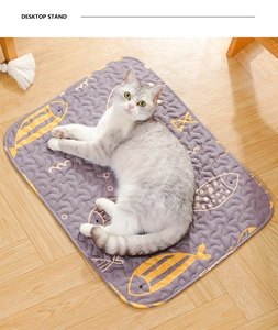 Detail of grey pet sleeping mat with yellow fish pattern and quilted texture on wood floor