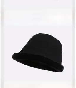 Close-up of fluffy black faux fur bucket hat with a premium brown leather brand logo tag