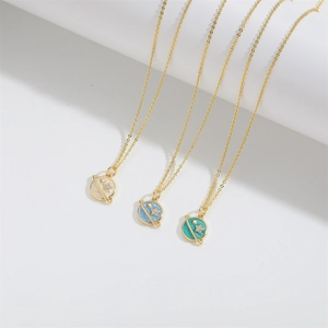 Vintage planet star pendants in cream, blue, and green on gold necklaces