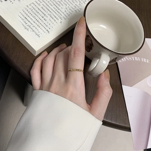 Bague dorée minimaliste à perles hexagonales pour femme présentée en mode lifestyle