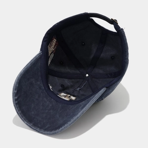 Detail view of washed cotton baseball cap with adjustable metal buckle and embroidery