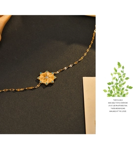 Macro view of 14K gold-plated starburst pendant with blue stones and zircon inlay