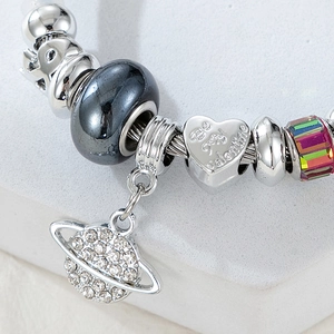 Macro view of Saturn charm and Be My Valentine heart bead on silver snake chain