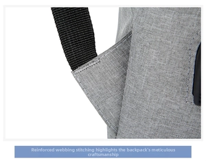 Close-up of reinforced stitching on grey fabric business backpack shoulder strap