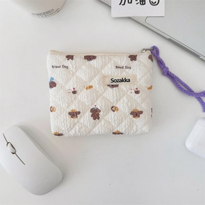 Detailed shot of quilted floral coin purse with Bread Dog pattern and purple zipper cord