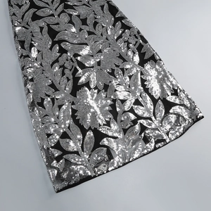 Détail de broderies florales argentées et de paillettes sur robe de soirée noire