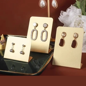 Three matte gold L-shaped metal earring display stands in varying heights for jewelry