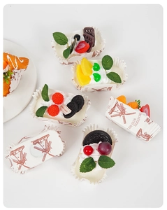 Macro shot of realistic fruit cupcake models with strawberry and cream toppings