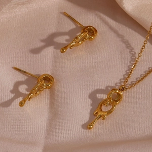 Lava-style gold jewelry set with necklace and earrings on premium champagne silk