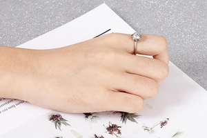 Detailed view of silver flower ring featuring central zircon stone on hand