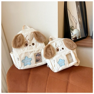 Detail view of dog-shaped canvas backpacks with star patches and plush fabric accents
