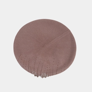 Detail of pink knitted beret featuring sparkling sequins and decorative patterns