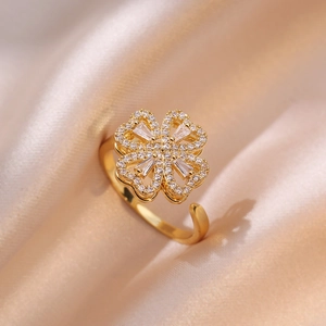 Golden clover ring with white zircon stones on champagne silk background