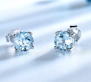 Vue macro des boucles d'oreilles clous en pierre bleue ronde avec sertissage à griffes