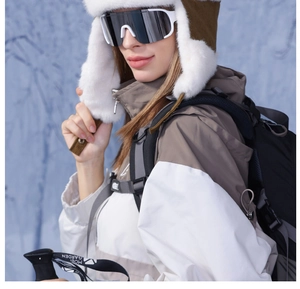 Close-up of winter trapper hat with ski goggles and windproof jacket for outdoor skiing