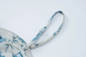 Détail de la fine bretelle réglable avec boucle argentée sur la robe d'été fleurie