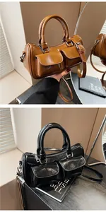 Detail view of brown and black leather cylinder handbags with dual magnetic front pockets