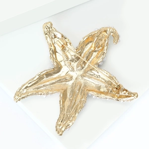 Detailed back view of a golden starfish brooch showing the secure pin fastener