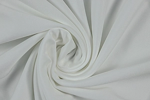 Detailed close-up of white pleated knit fabric texture with elegant spiral folding
