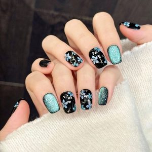 Short square black press-on nails with blue cat-eye glitter and hand-painted floral art