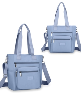 Detail view of light blue nylon handbag with multiple pockets and adjustable shoulder strap