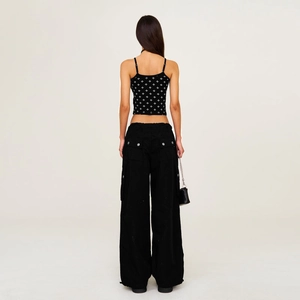 Vue arrière d'un mannequin portant un pantalon cargo noir à poches et un caraco imprimé