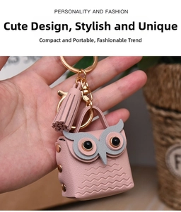Pink leather owl coin purse keychain with gold hardware and tassel detail shown in hand
