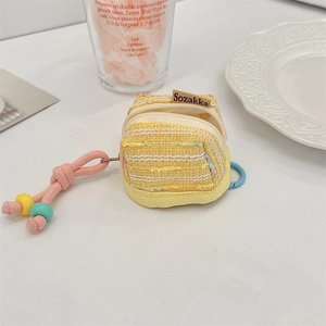 Detail of yellow tweed mini earphone pouch with pink knotted lanyard decor