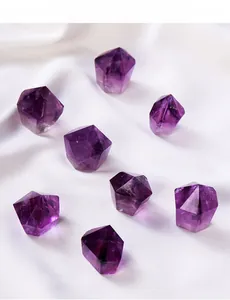 Close-up of eight natural purple amethyst hexagonal prisms on white silk fabric