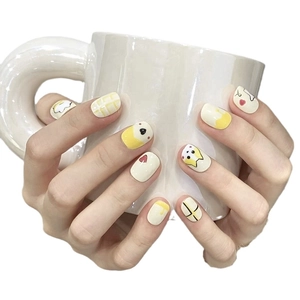 Short square press-on nails with yellow corgi drawings and egg patterns