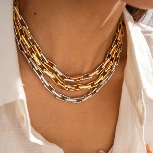 Close-up of layered chunky metal link necklace in two-tone gold and silver finish
