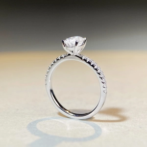 S925 sterling silver moissanite ring with four-prong setting and pavé diamonds