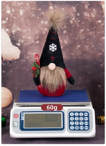 Close-up of a lightweight Christmas gnome plush weighing 60g on a digital scale