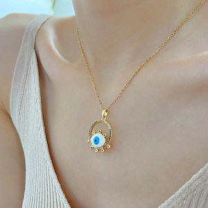 Golden Evil Eye pendant necklace with colorful zircon inlay shown on a model neck
