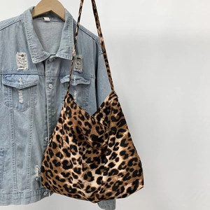 Leopard print canvas tote bag hanging on a denim jacket to show size and style