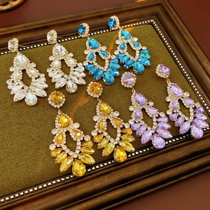 Detailed display of rhinestone drop tassel earrings in white, blue, yellow and purple