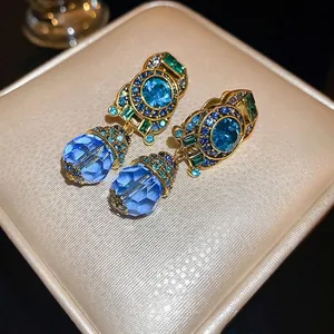 Vintage gold-tone earrings with large blue crystal drops and colorful rhinestone accents