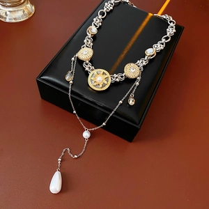 Detail view of double-layer necklace with sun-pattern pendant and teardrop pearl in gift box