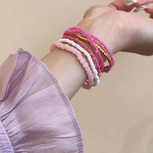 Detail of colorful Bohemian beaded bracelet set stacked on a model's wrist in bright tones